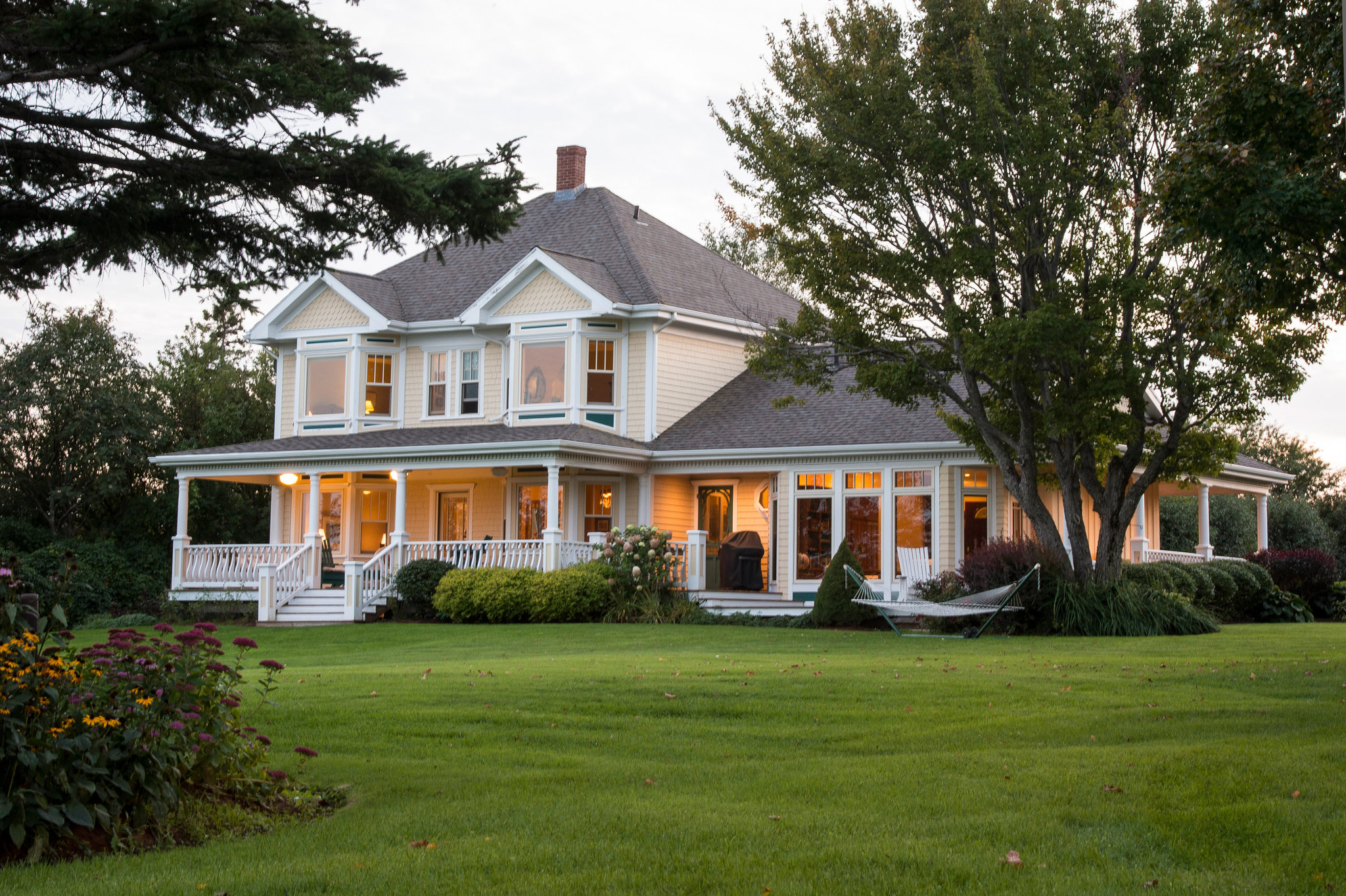 White Victorian farmhouse with wraparound porch